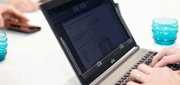 Ihmisen kädet kannettavan tietokoneen näppäimistöllä, kuvituskuva.