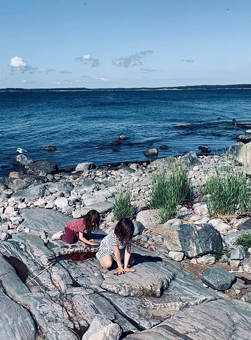 Lapset rantakalliolla.