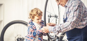 Aikuinen ja lapsi korjaavat polkupyörää, kuvituskuva.